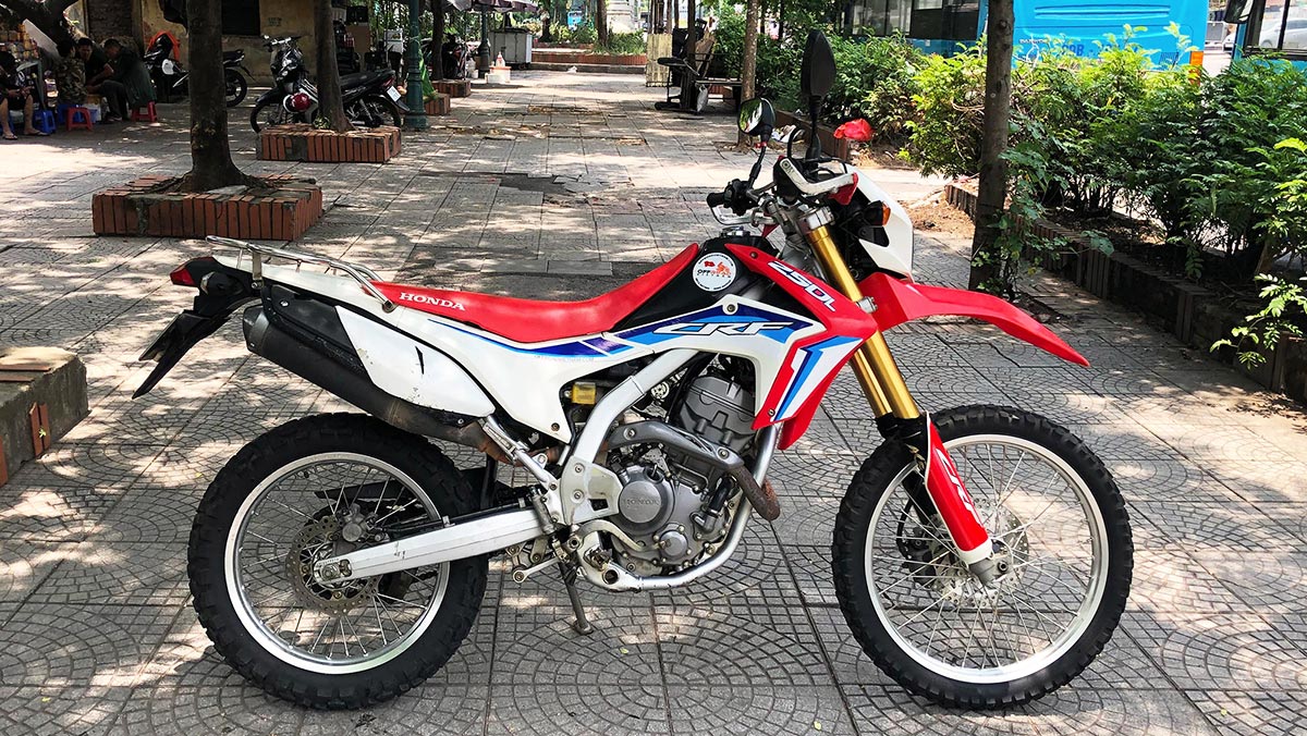 Offroad Vietnam Dirt Bike Rental - 2014-2017 Honda dirt (trail) bike Honda CRF250L 250cc Red & White, front disc brake, back drum brake. From right. New 2022 sticker.